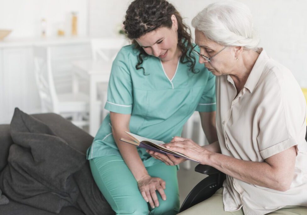 nurse-looking-senior-woman-reading-book